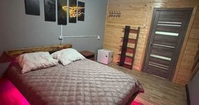 Номер 4 комната 1: двуспальная кровать, прикроватная тумба, полка для одежды, маленький холодильник, лицевые полотенца (апрель 2026).