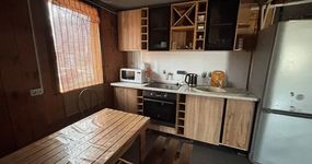 Кухонная зона: стол, лавочки, кухонный гарнитур, плита, микроволновая печь, чайник, холодильник (апрель 2026).