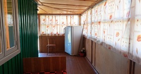 Дом №4 - кухонная зона (холодильник, эл.плита, стол, стулья). Спальные места (5 односпальных деревянных кроватей, тумбочки)