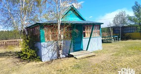 Дом №4 - кухонная зона (холодильник, эл.плита, стол, стулья). Спальные места (5 односпальных деревянных кроватей, тумбочки) (май 2025)